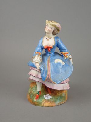figurine représentant une femme en robe bleue, assise sur un rocher