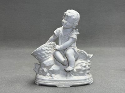 Jardinière en biscuit figurant un bébé sur des paniers.