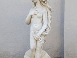 une statue représentant une femme tenant un coquillage, posée au sol