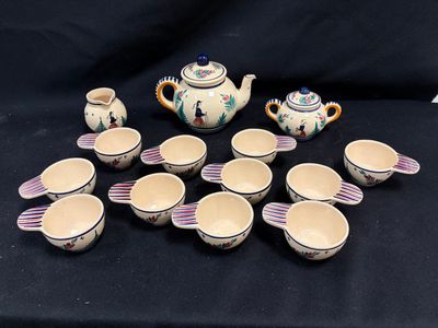 une image représentant un ensemble de tasses et une théière posées sur une table