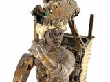 statue of a man with a bird on his head holding a musical instrument