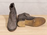 pair of men ' s brown leather boots on a wooden table