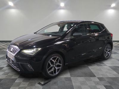 la voiture noire est garée sur un sol en damier dans le garage