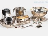 un plateau en argent sur lequel sont disposés des assiettes et des cuillères en argent