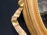 a mirror with a gold frame hanging on the wall