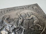 a silver box that has a picture of a man and a goat on it