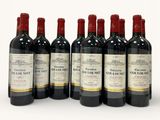 six bottles of red wine lined up in a row on a white surface