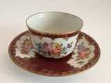 a cup and saucer on a saucer on a white table
