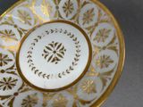 a white and gold plate with gold designs on it