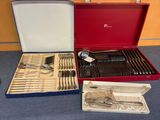 un coffret rouge contenant de l'argenterie sur une table