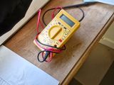 a dog that is sitting on a table with a multimeter