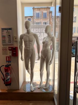deux mannequins qui se tiennent devant une vitrine