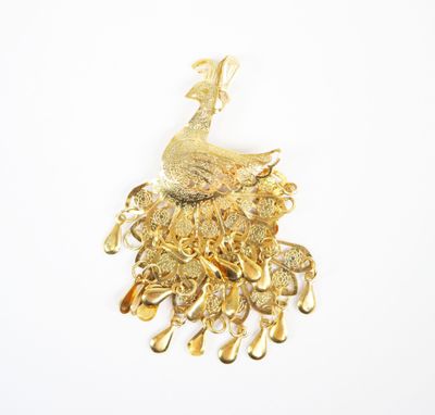 an image of a gold peacock brooch on a white background