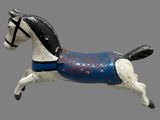 a small wooden horse with a blue blanket on it ' s back