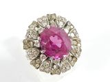 a close up of a pink stone and diamond ring on a white surface