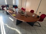 une photo d'une salle de réunion avec une longue table et des chaises rouges