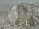 a lot of glass goblets and wine glasses sitting on a table