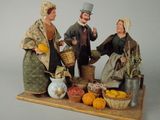 une figurine représentant un homme et une femme avec un panier de fruits