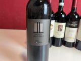 several bottles of red wine are lined up on a table
