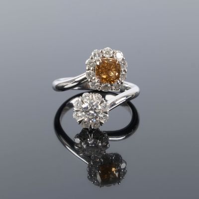 a close up of two rings with diamonds on a reflective surface