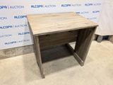 La table est en bois et comporte un tiroir en dessous.