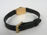 a close up of a black leather bracelet with a gold clasp