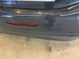 the rear end of a blue car with a sticker on it