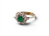 un gros plan d'une bague en diamant verte et blanche sur fond blanc