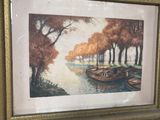 two framed pictures of boats on a river with trees in the background
