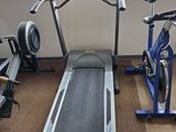 a tread machine in a gym room with a window in the background