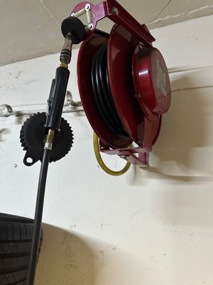 a red fire hydrant hanging from a wall next to a tire