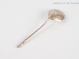 a silver spoon with a handle on a white surface