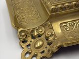 a gold clock with a black dial on it