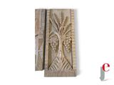 carved wood panel with a tree and grapes on it