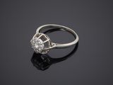 a white gold and diamond ring on a black surface