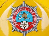 a yellow fire hydrant with a badge on it