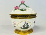 une boîte blanche et dorée ornée de fleurs roses
