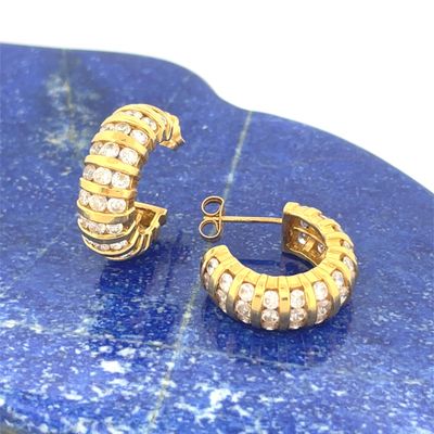 pair of goldtone and crystal hoop earrings on a blue marble slab