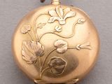 an image of a gold pocket watch with flowers on it