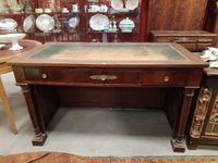 Bureau en acajou présentant trois tiroirs en bandeau.