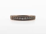 a close up of a ring with a row of diamonds on it