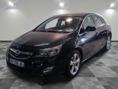 L'Opel noire est garée dans une grande pièce au sol carrelé en damier.