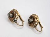 pair of gold tone earrings with black and white stones