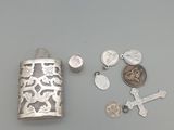 une flasque en argent ornée d'une croix, d'une pièce de monnaie et d'une autre croix