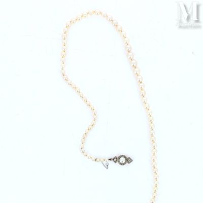 a close up of a necklace on a white surface with a chain