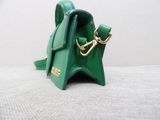 a small green purse that is sitting on a table