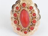 une image d'une bague en or avec une pierre rouge au centre