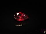 a close up of a red diamond on a black surface