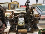 a clock sitting on top of a table next to a pile of books