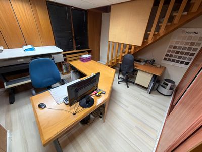 a desk with a computer and a chair in the room